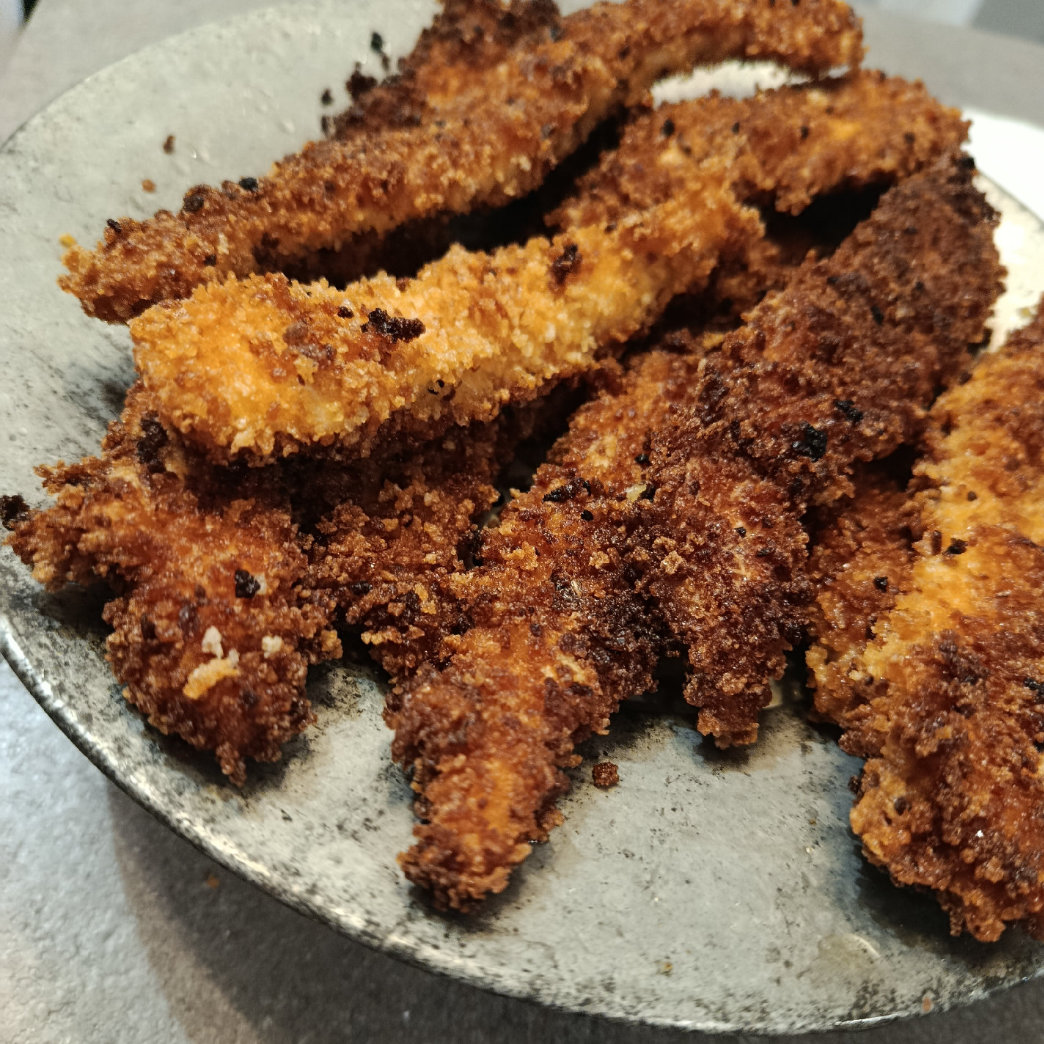 Immagine di Straccetti di pollo fritti con pangrattato, zenzero e buccia di limone.